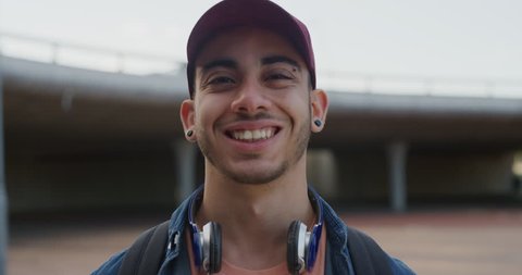 close up portrait attractive young hispanic teenage man smiling happy enjoying successful lifestyle male student looking confident wearing hat slow motion real people series