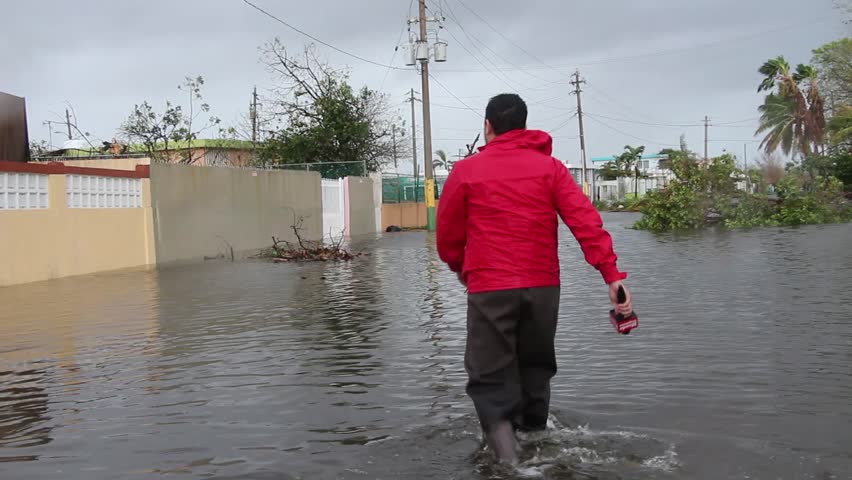 Man walks across flood waters after Hurricane Maria