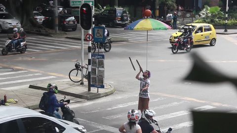 Medellin, Colombia - July 2, 2018: A Venezuelan immigrant juggling swords at a traffic light in Colombia