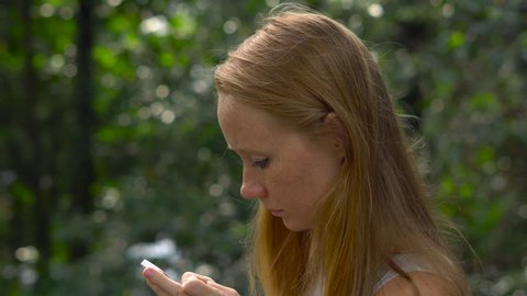 Young woman in a park using a cellphone