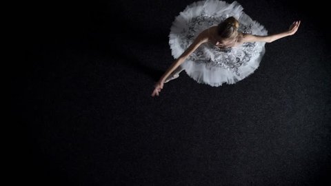 Silhouette of young woman ballerina in tutu is moving and spining from one corner to another, ballet concept, movement concept, top shot