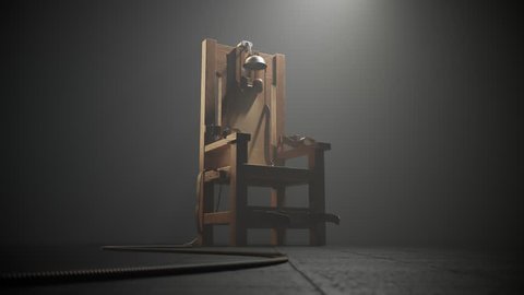 03497 Electric chair in the spotlight. Camera track in.