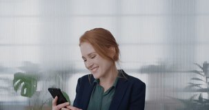 portrait young happy red head business woman using smartphone video chatting blow kiss enjoying mobile phone communication laughing cheerful slow motion sharing connectedness