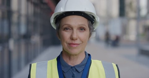 portrait successful senior construction engineer woman smiling enjoying professional career success wearing hard hat safety helmet slow motion female ambition