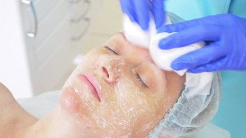 Close up of beauty procedure. Beautician cleaning facial mask. Peeling. Beauty and body skin care. slow motion 4k