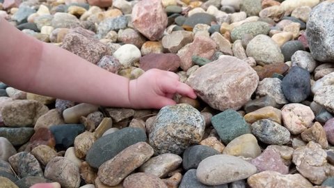 Toddler Playing and Picking up Stones with Tiny Hands