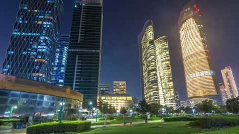 Skyscrapers in Abu Dhabi Skyline at night timelapse hyperlapse, United Arab Emirates. View from Corniche with illuminated modern towers
