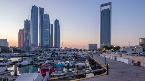  marina Abu Dhabi day to night timelapse after sunset with boats and illuminated modern skyscrapers on background