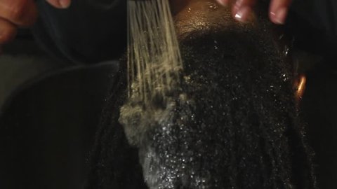 Woman getting her locs shampooed/rinsed