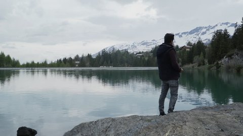 Rear view of a person doing ricochets on a lake in the alps