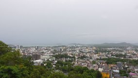 Phuket city from mountain view point seeing downtown and andaman coastline with grey cloud sky in rainy season,4K video.
Phuket town ,wide angle view. 

