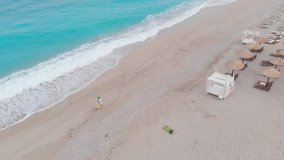 Aerial  view of woman  while walking on the sandy ocean beach in the morning, luxury summer holidays