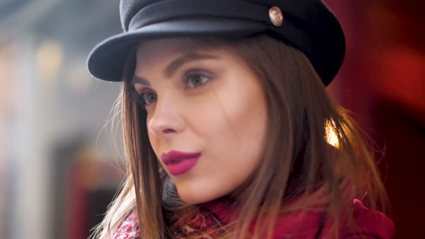 Face fashion woman in black cap and red scarf on city street background