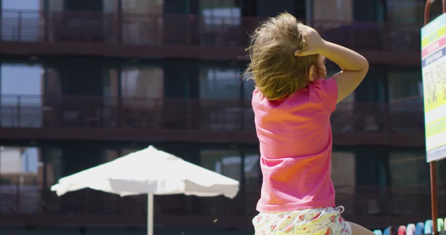 happy little girl portrait in playground with wind in hair shoot in slow motion