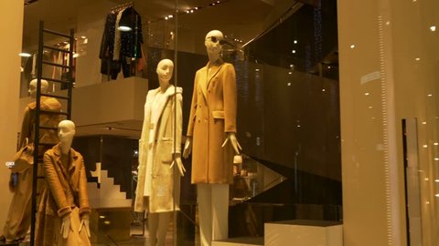 Elegant female mannequins near stairs in a fashion shop showcase