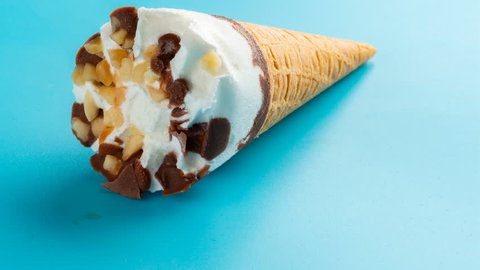 studio shoot mini white ice cream cone melting on blue time lapse