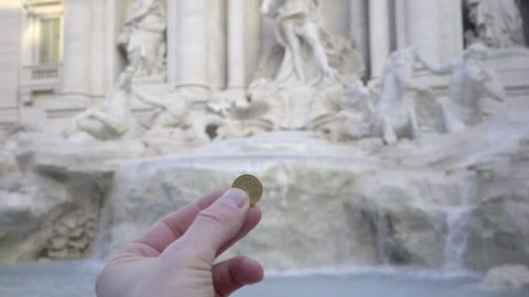 A coin is thrown into the Trevi Fountain. Rome italy
