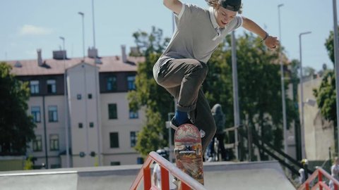 Young skater doing tricks outdoors. Slowmotion video 150fps