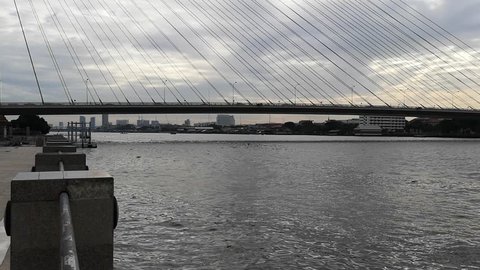 Riverside view of water waves under hanging bridge