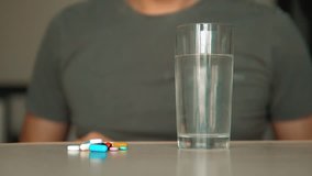 man taking pills at home is ill sick slow motion video. Healthcare and medical concept disease. male takes lifestyle a pill and drinks a glass of water indoors