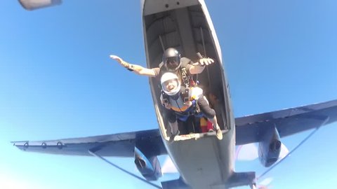 Skydiving. Tandem is jumping out of a plane and two friends are flying to the one.
