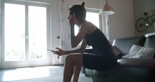 young tattooed woman using smartphone for tracking during home fitness sport workout .Living room domestic training. 4k slow motion video