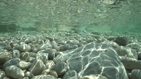 Pebbles below water surface in shallow water in the Mediterranean sea, underwater scene, natural sunlight, Javea , Alicante, Valencia, Spain