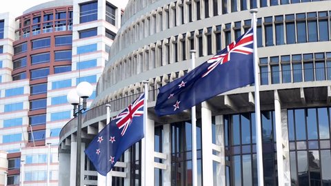 New Zealand flags flying outside the 'Beehive' , the Executive Wing of the New Zealand Parliament Buildings in Wellington, New Zealand