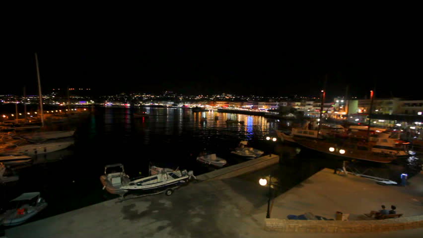Beautiful night sea landscape. Greece. Bright colorful lights of the coast are reflected in the sea water