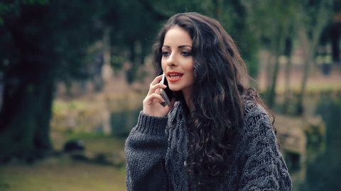 
young nervous woman talking on the phone in the park Video Stok