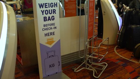 A woman checks the weight of the baggage at the airport