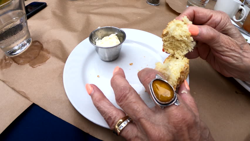 Elderly woman hands eating a scone or biscuit | Shutterstock HD Video #1013238764