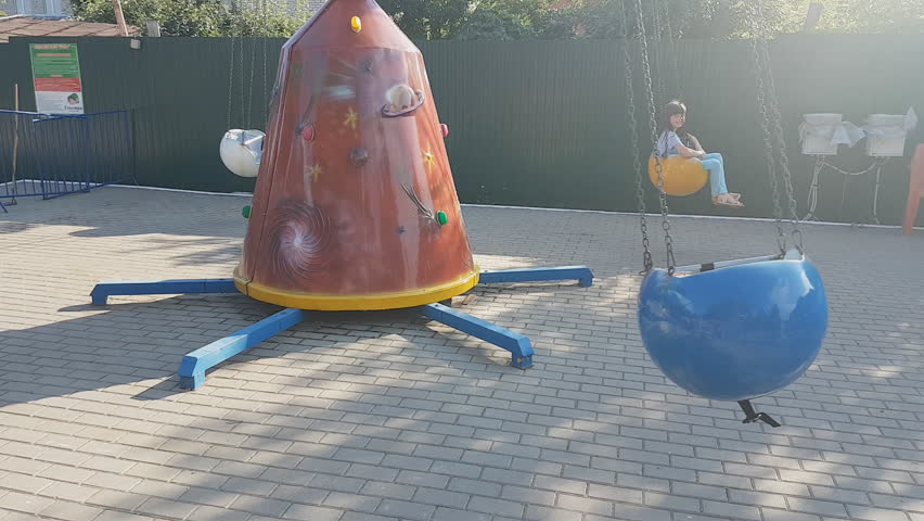 Joyful kids screaming and raising arms while riding roller coaster in amusement park