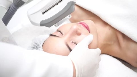 Young Asian woman getting IPL and laser treatment by beautician at beauty clinic