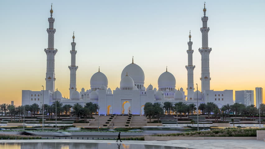Sheikh Zayed Grand Mosque in Abu Dhabi day to night transition timelapse after sunset, UAE. Evening view from Wahat Al Karama with reflections on water | Shutterstock HD Video #1013248034