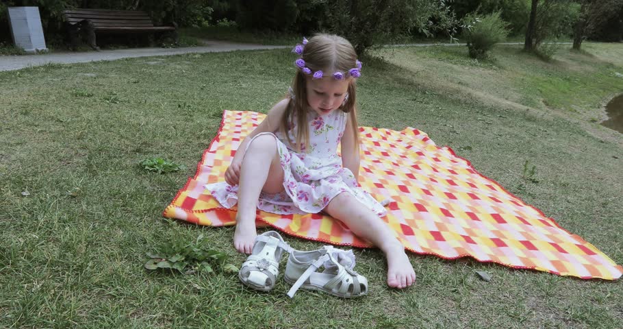 On the green grass girl child wipes his hands wet cloth