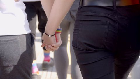 Lesbian Couple Walking Hand To Hand In Pride Day
