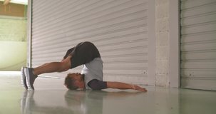 Young adult man warming up stretching during fitness sport workout.Side view .Grunge industrial urban training.4k slow motion video