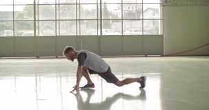 Young adult man warming up stretching during fitness sport workout.Front view .Grunge industrial urban training.4k slow motion video