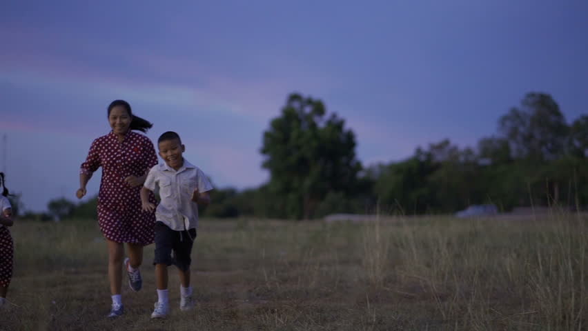 Asian families, Mother son and daughter are running happily on holiday grounds.