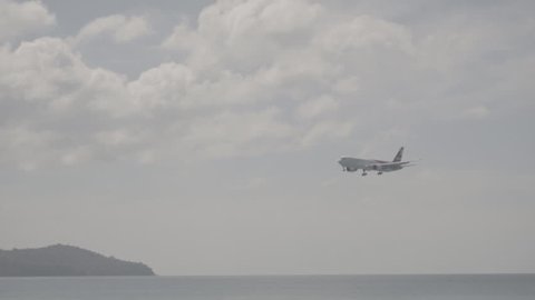 PHUKET, THAILAND - NOVEMBER 27, 2016: Side view of Boeing 777 of Ikar airlines on final approach to Phuket International airport. S-log, ungraded