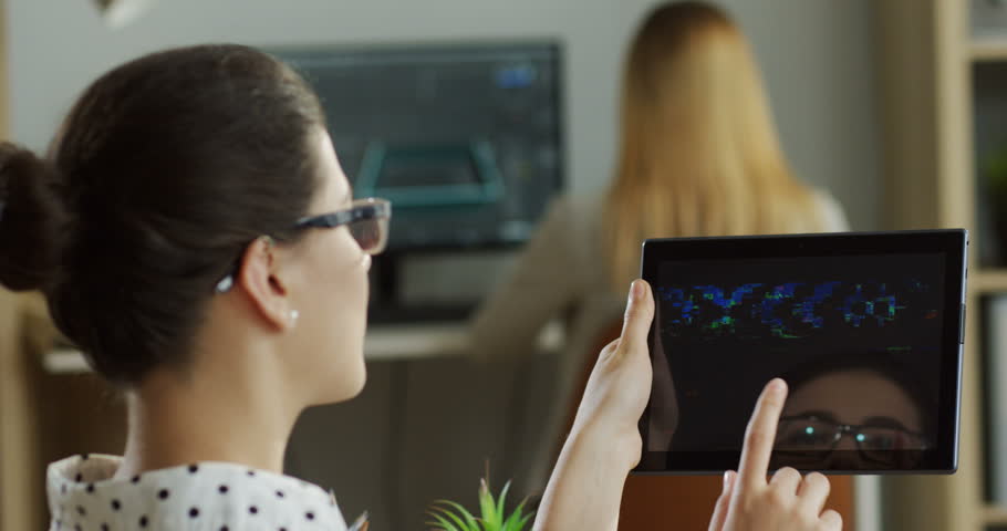 Close up of the back view on the caucasian young woman using tablet device with broken screen and it not working. At the office. Indoors.