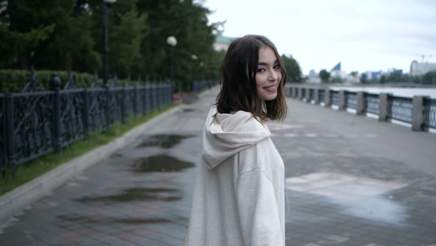 Brunette is taking a walk along the river side
