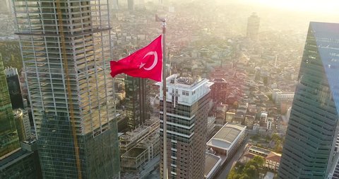 Turkish flag swinging in the middle of the financial city at sunset
