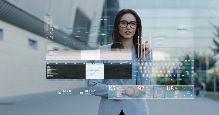 Young beautiful woman in business style and glasses standing near office center. taping in the air and rulling a commerce hologram. Outdoors.