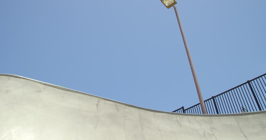 Slow motion skateboarder doing extreme air on vert ramp in skatepark