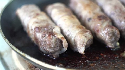 Preparation of meat dish from minced meat wrapped in bacon with white veins.