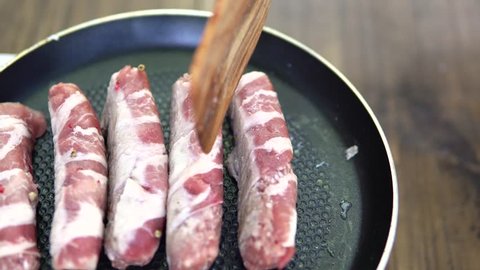 Preparation of meat dish from minced meat wrapped in bacon with white veins.