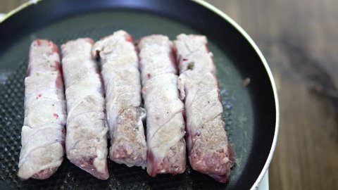 Preparation of meat dish from minced meat wrapped in bacon with white veins. 