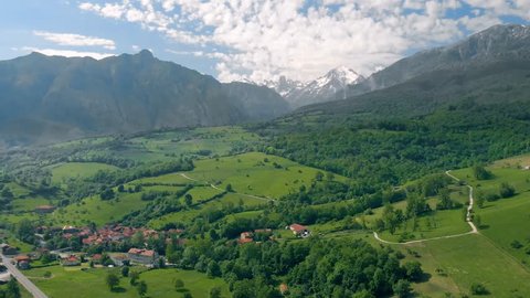 Panoramic aerial view of green valley with Naranjo de Bulnes mountain peak on the background in the Picos de Europa national park in northern Spain